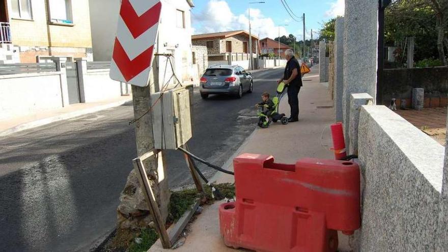 Un peatón tienen que invadir la calzada por los obstáculos en las aceras de la Estrada do Galleiro. // Faro