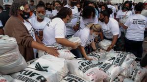 Un grupo de vecinos gestionan la recepción de alimentos donados en una favela.