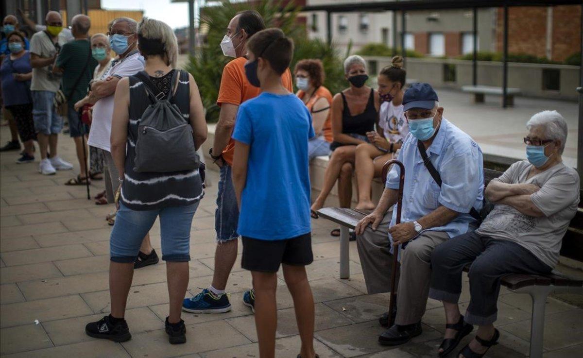 Gente con mascarilla espera su turno para realizarse una prueba PCR en Santa Coloma de Gramenet. 