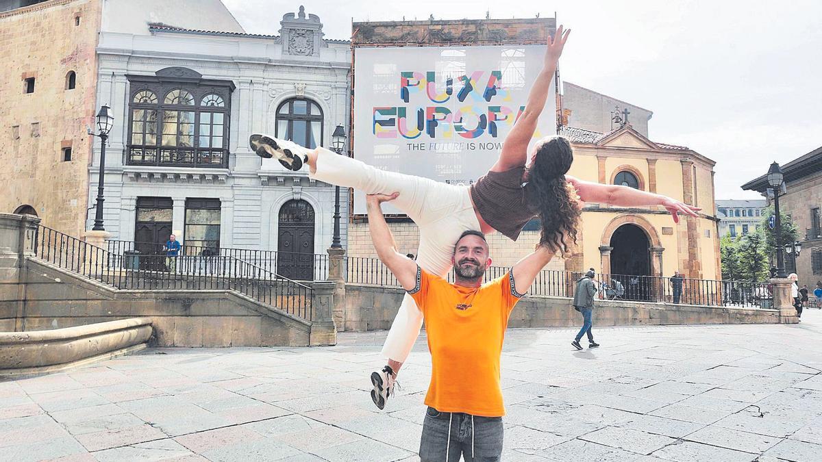 Dos bailarines hacen un porté delante de la lona con el lema de la capitalidad cultural.