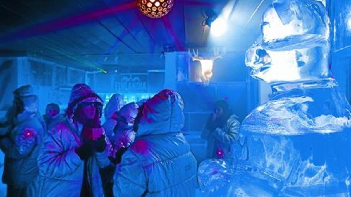 Helados 8Unos clientes toman sus copas en el Icebarcelona, junto a una escultura de hielo.