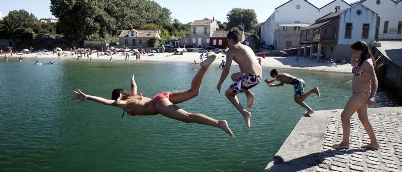 Jóvenes bañistas se zambullen en el mar en Alcabre. // M. Canosa