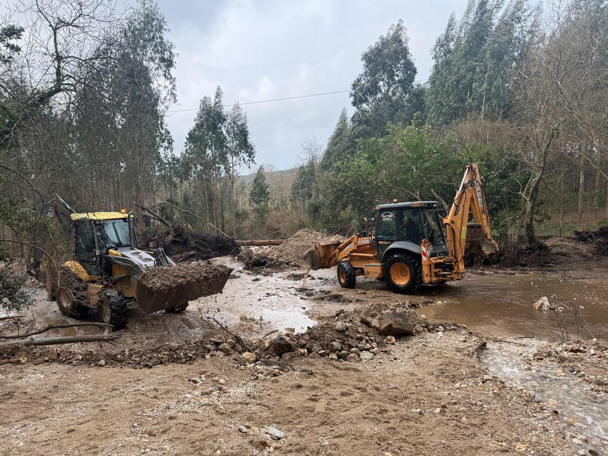 Palas retirando piedras, lodo y árboles arrastrados por el agua de la balsa minera.