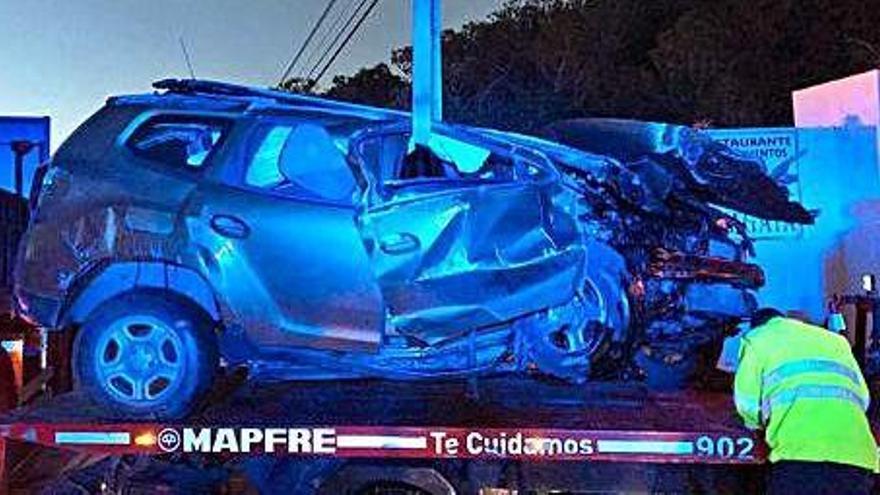 El coche es retirado de la calzada después de que los bomberos rescataran al conductor de su interior.