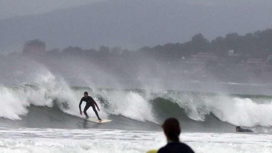 Surfistas en la playa de Patos, ayer por la tarde, disfrutando del fuerte oleaje. // Ricardo Grobas