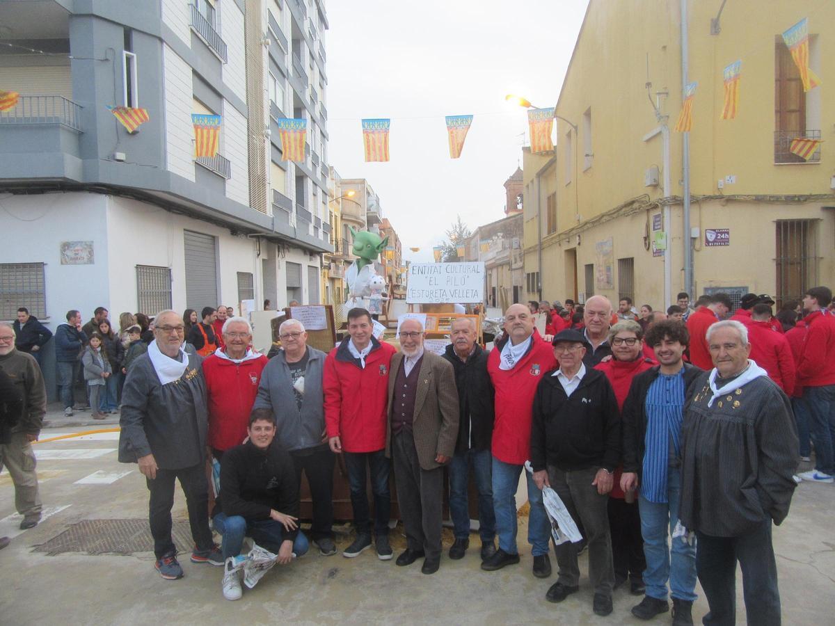 Miembros de El Piló y autoridades municipales delante del monumento.