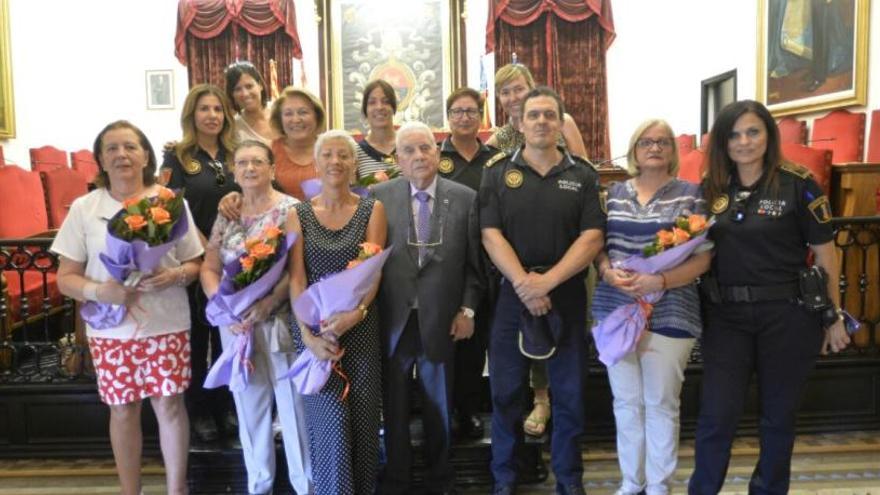 Las primeras ocho mujeres que fueron Policía Local en Elche,con su ramo, junto a otras compañeras en el homenaje de esta mañana