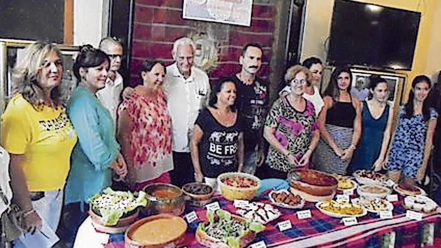 Los participantes en el encuentro culinario posan con sus platos.