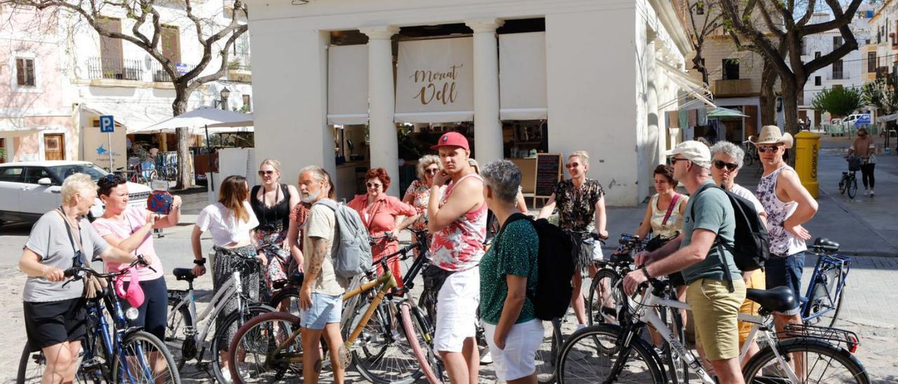 Un grupo de turistas en bicicleta en el Mercat Vell de Eivissa.