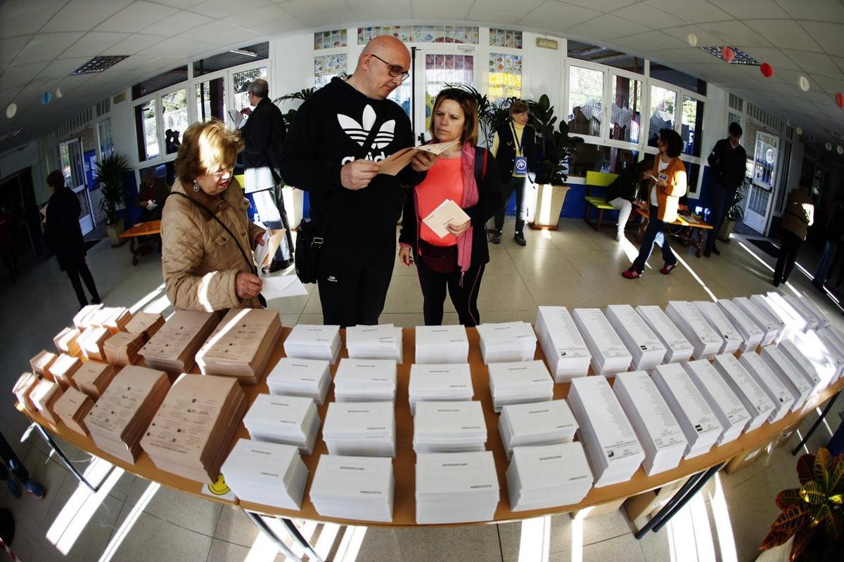 GRAF9259. MADRID, 28/04/2019.- Los primeros votantes del colegio público Pinar del Rey de Madrid recogen papeletas electorales para ejercer su derecho al voto. Los colegios electorales han abierto sus puertas a las 09:00 horas para recoger el voto de los casi 36,9 millones de electores que decidirán este domingo en los comicios generales el reparto de los 350 escaños del Congreso de los Diputados y los 208 del Senado durante la próxima legislatura. Tras la constitución de las mesas a las ocho de la mañana con la comprobación de que estaban los miembros necesarios y la lectura de los manuales, a las nueve de la mañana los electores han comenzado a acudir a las urnas, en una jornada que estará marcada por el sol y con temperaturas, en general, al alza en casi todo el país.-EFE/Javier Lizón.