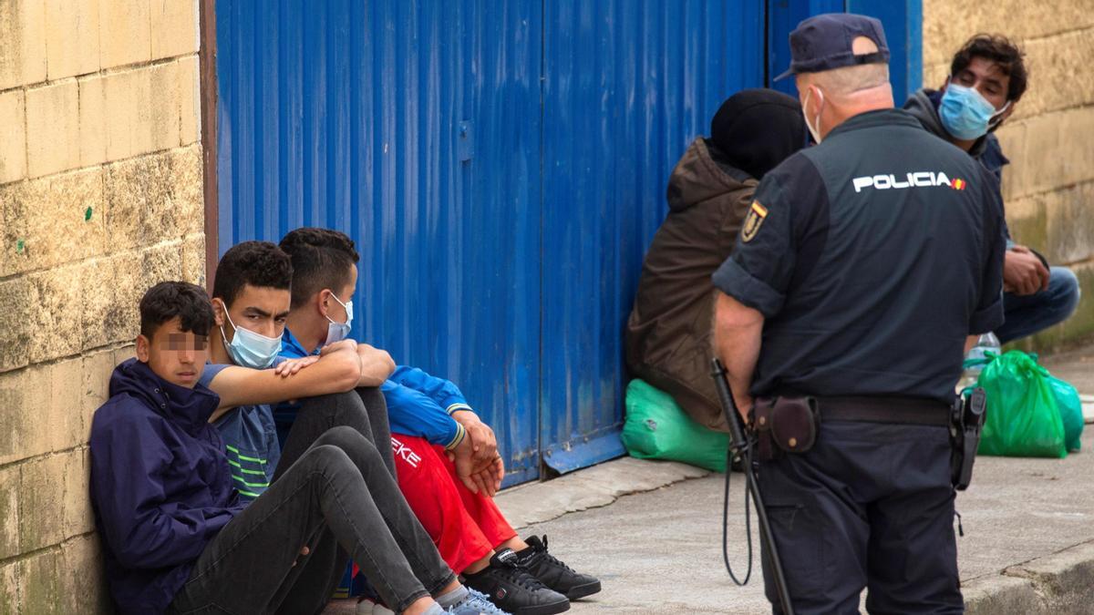 Varios inmigrantes menores en el polígono industrial cercano a la frontera de El Tarajal, en Ceuta.