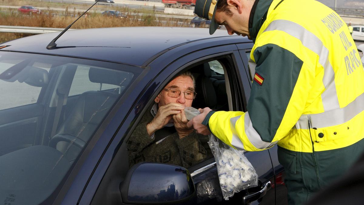 Un Guardia Civil somete a un control de alcoholemia a un conductor.