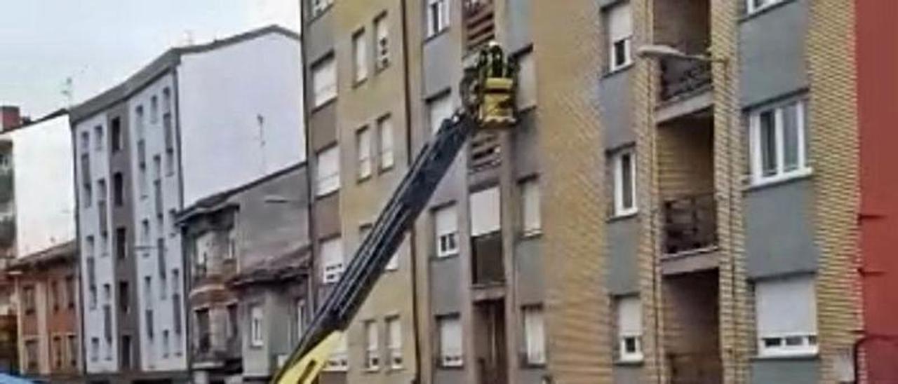 Intervención de los bomberos para retirar las macetas de una ventana en la avenida de Gijón, en Pola de Siero. | R. A. I.