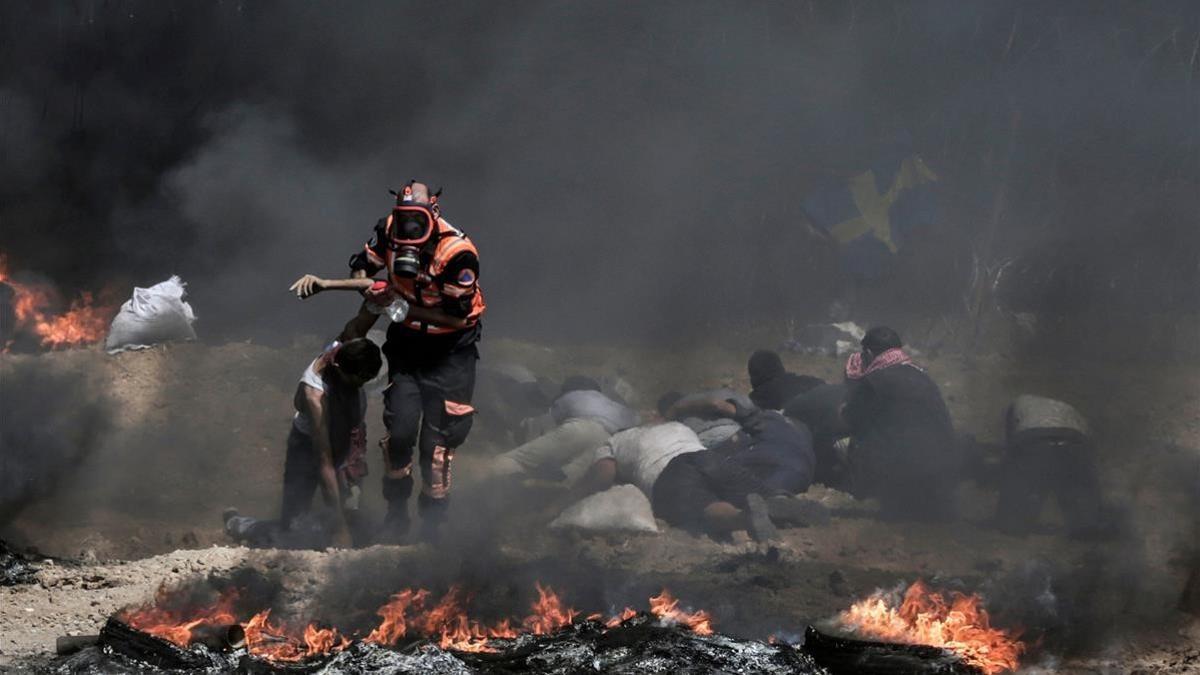 Un sanitario ayuda a un herido, ayer en Gaza.