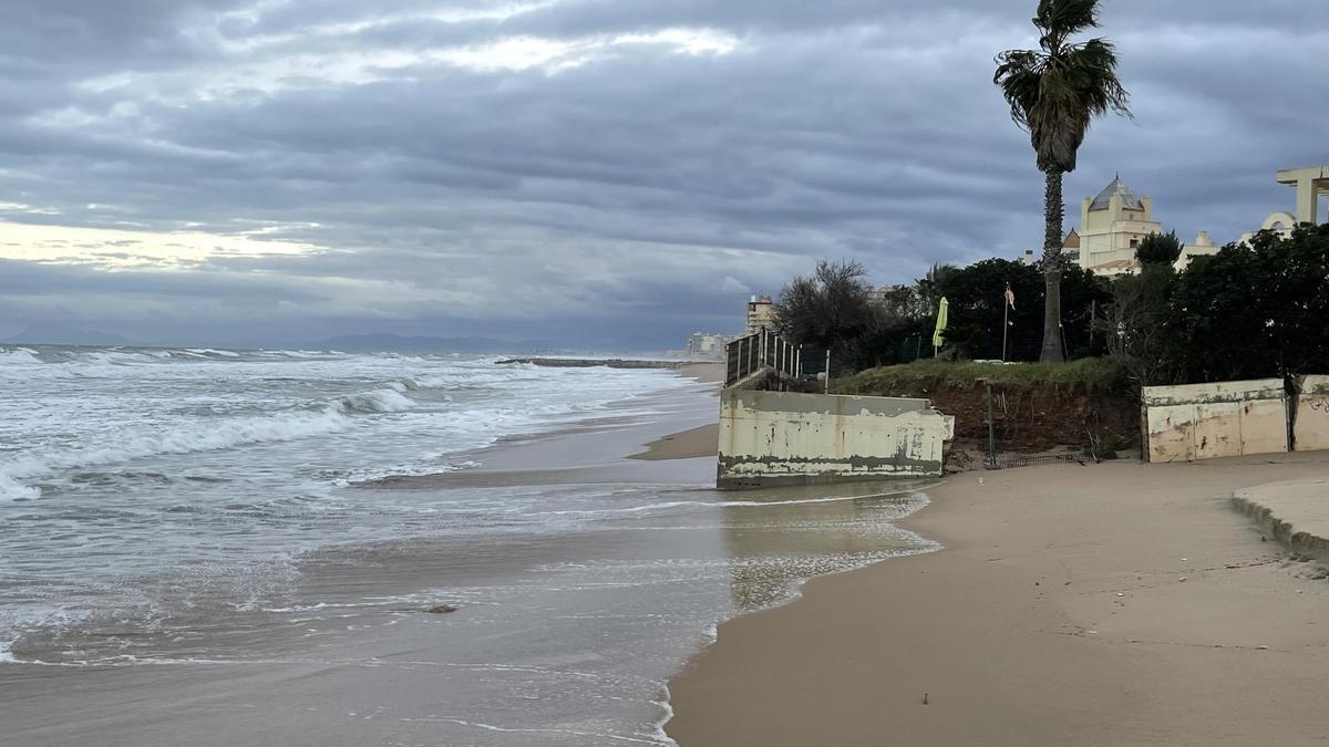 La playa de la Goleta de Tavernes de la Valldigna,en febrero, con el agua llegando a los muros de los edificios.