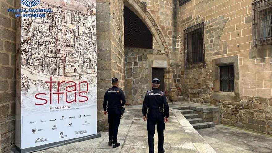 Una patrulla de la Policía Nacional de Plasencia, junto al cartel de la exposición de Las Edades del Hombre.