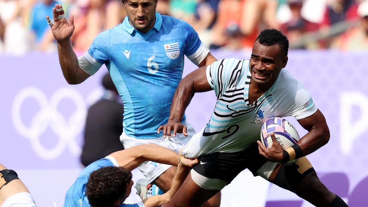 Jerry Tuwai de Fiji pugna con James McCubbin de Uruguay durante un partido de rugby en los JJOO. en París 2024