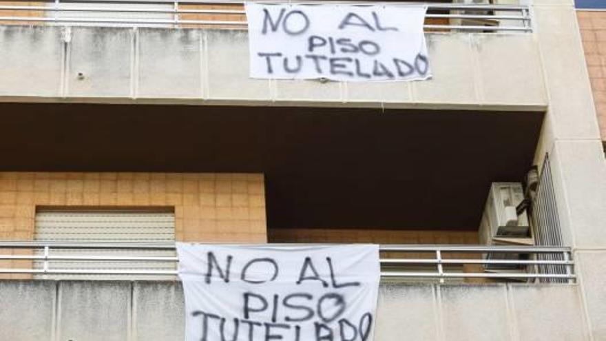 Varias pancartas con el lema «No al piso tutelado» cuelgan de los balcones.