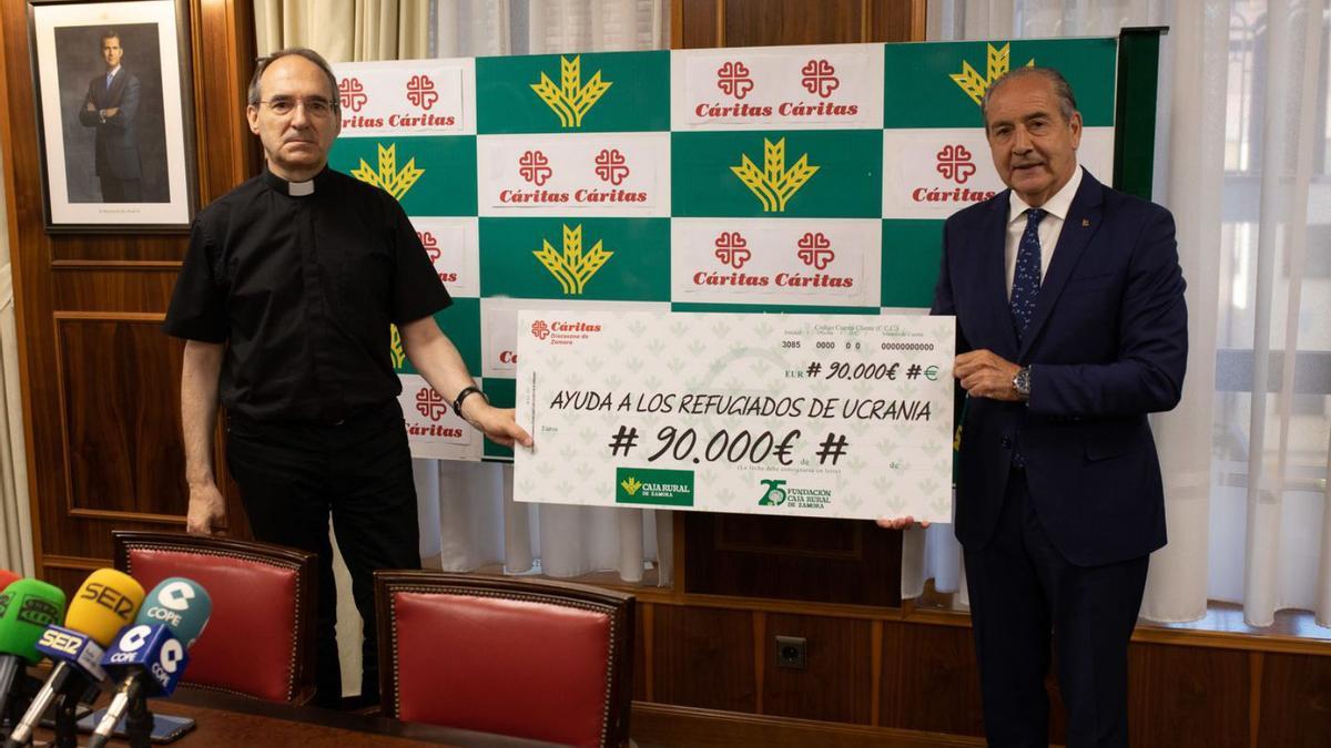 El director de Caja Rural, Cipriano García Rodríguez, entrega un donativo para refugiados ucranianos al responsable de Cáritas, Antonio Martín de Lera.