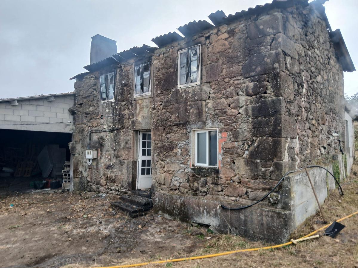 Fachada de la vivienda calcinada este lunes en A Baña.