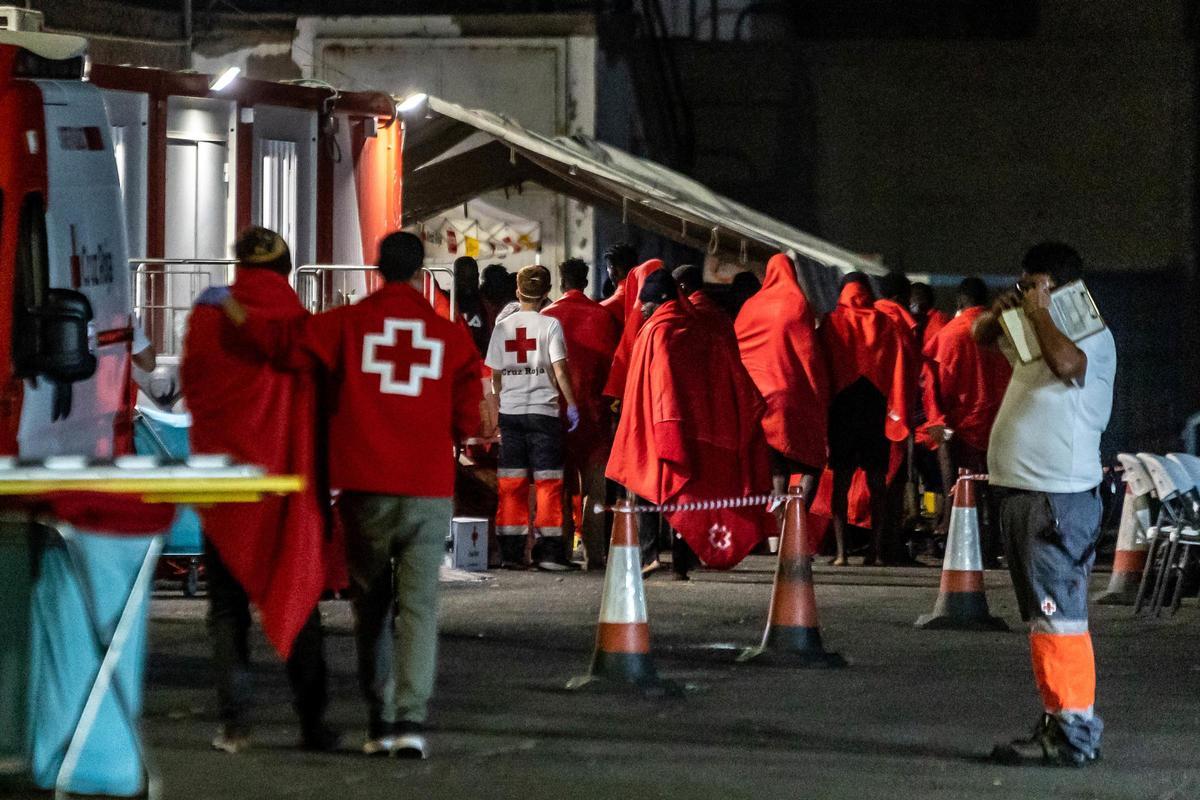 Archivo - Trabajadores de la Cruz Roja reciben a las personas de un cayuco, rescatadas por una embarcación de Salvamento Marítimo, en el muelle de Arguineguín, a 23 de julio de 2024, en Gran Canaria