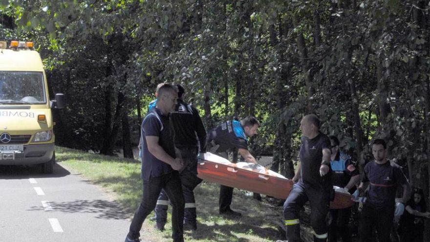 Bomberos y agentes retiran el cadáver.