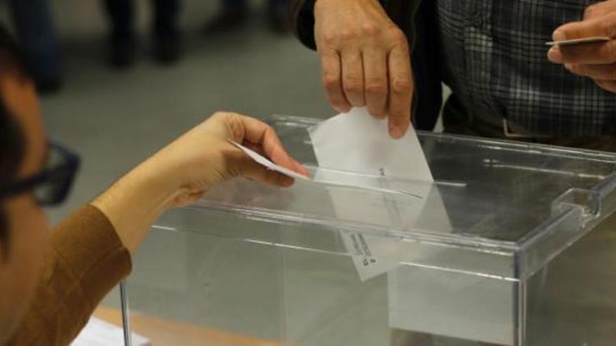 Un votant introdueix el seu vot en una urna
