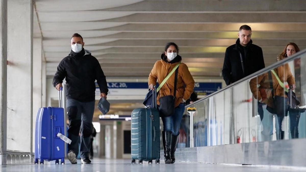 Una pareja con mascarillas en el aeropuerto Charles de Gaulle.