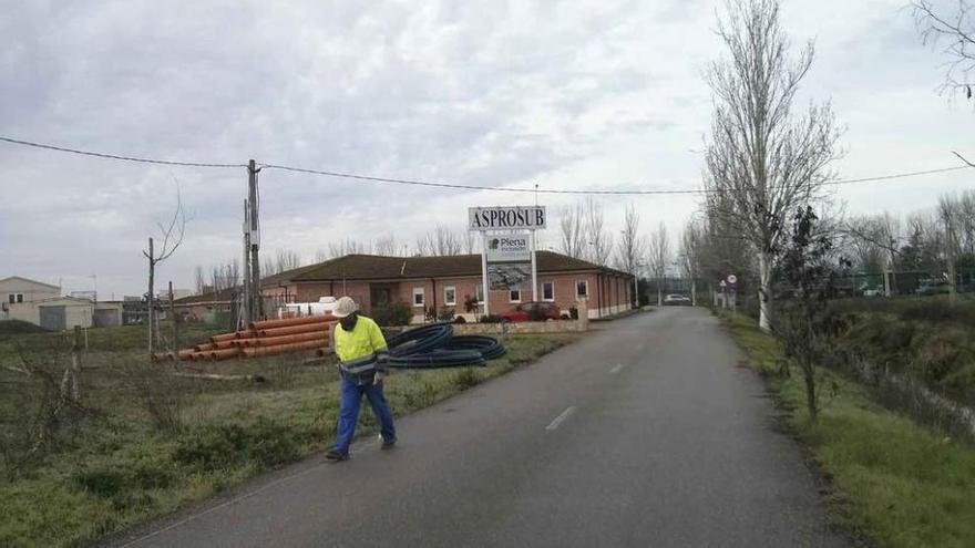 Un trabajador junto a las instalaciones de Asprosub (al fondo).