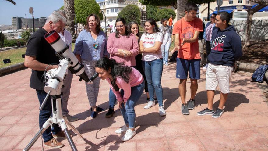 Una alumna mira por el nuevo telescopio ante la atenta mirada de la consejera Soledad Monzón y profesores, ayer.