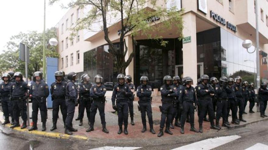 Miembros de las Unidades de Intervención Policial (UIP) vigilan la sede de la Policía Local de Coslada, después de la detención de una treintena de agentes de este cuerpo, acusados de extorsión en bares de copas y comercios.