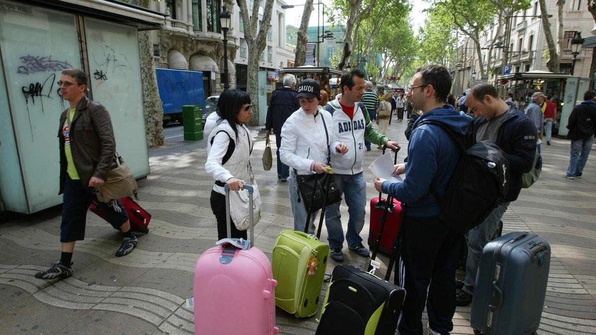Turistas con maletas en la Rambla de Barcelona.