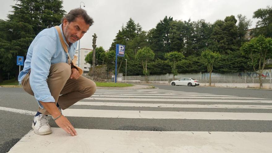 José Arufe, con cabestrillo, toca la pintura del paso de peatones en el sufrió el accidente de moto, donde no se aprecia antideslizante