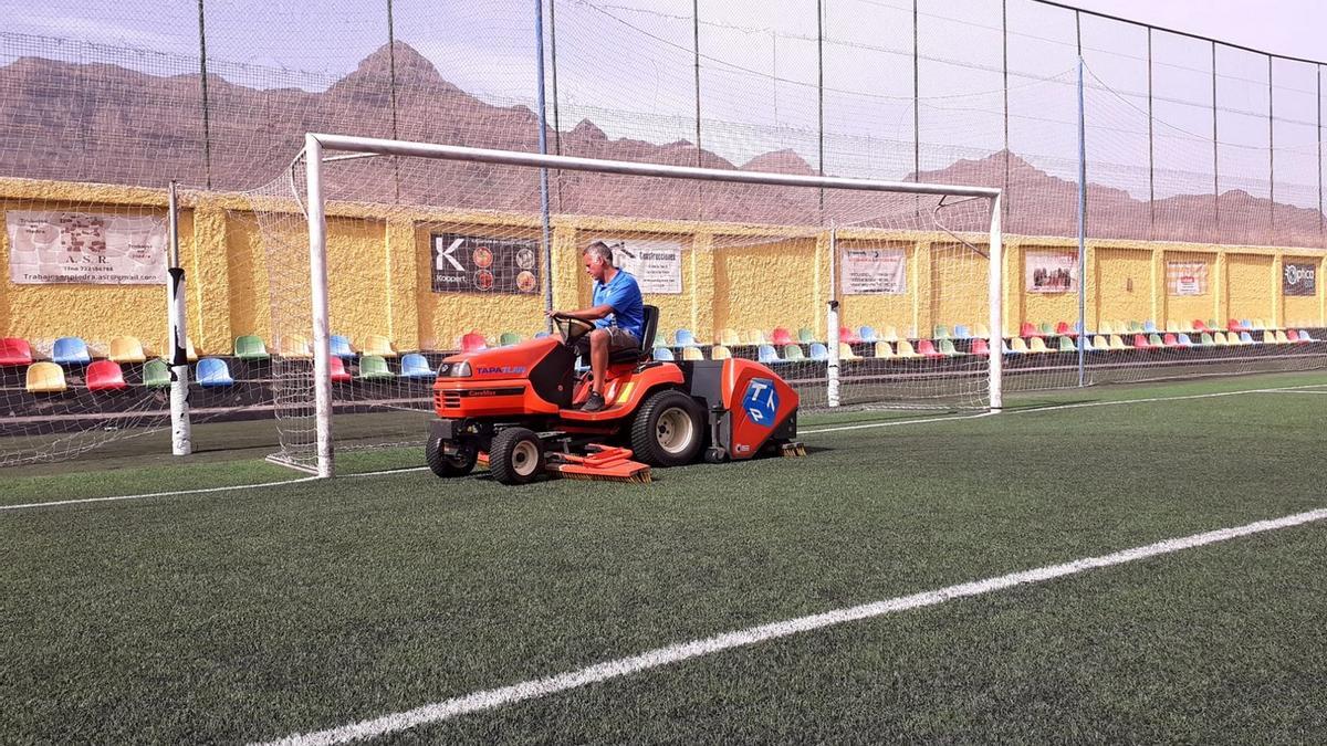 Imagen del mantenimiento del césped artificial en el campo de fútbol de Los Cascajos, en La Aldea de San Nicolás.