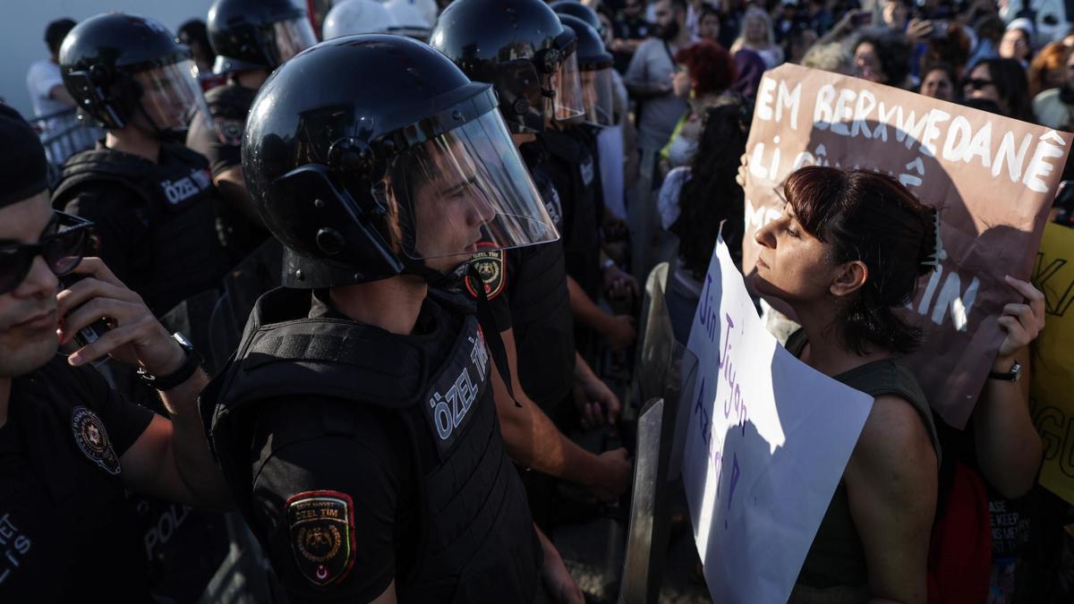Una mujer con una pancarta se enfrenta a la policía antidisturbios que les bloquea, participa en una concentración para conmemorar el primer aniversario de la muerte de la mujer iraní Mahsa Amini, en Estambul, Turquía.