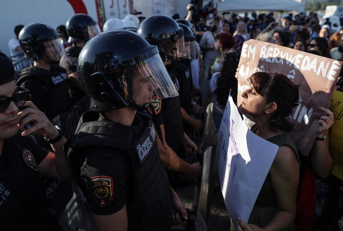 Una mujer con una pancarta se enfrenta a la policía antidisturbios que les bloquea, participa en una concentración para conmemorar el primer aniversario de la muerte de la mujer iraní Mahsa Amini, en Estambul, Turquía.