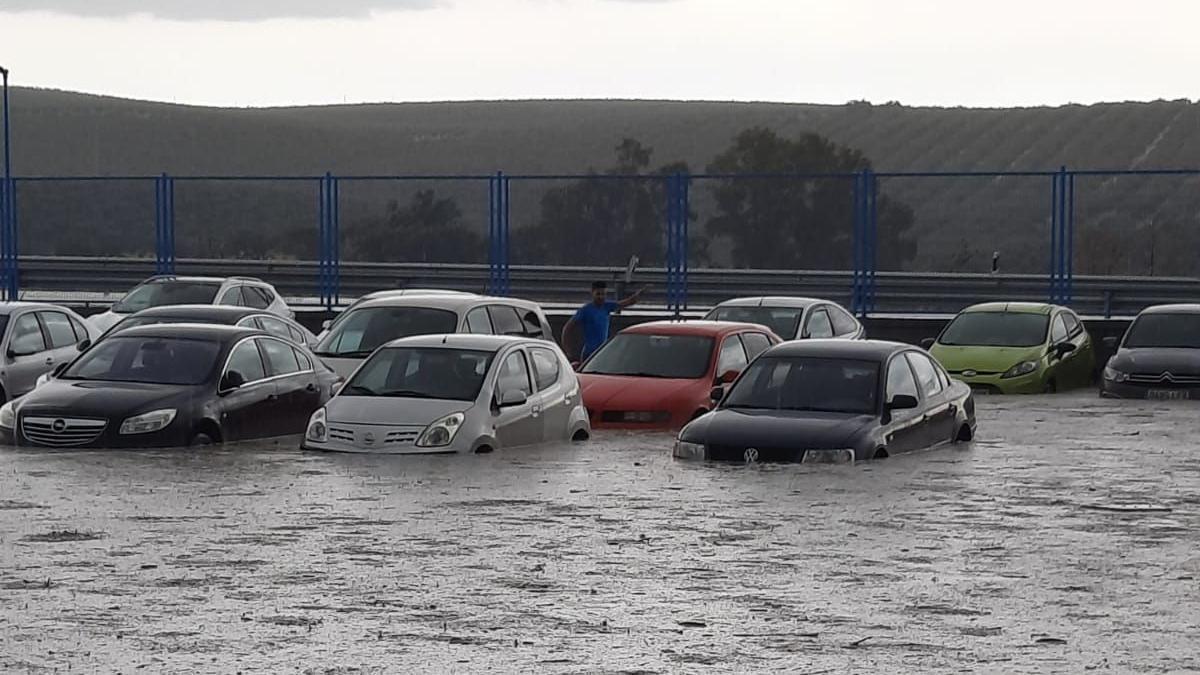 Coches atrapados por el agua que inundó ayer un párking en Lucena.