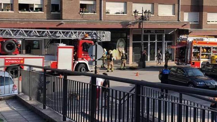 Dos camiones de bomberos, ayer, a la entrada del supermercado incendiado en la calle Luis Suárez Ximielga de Colloto.