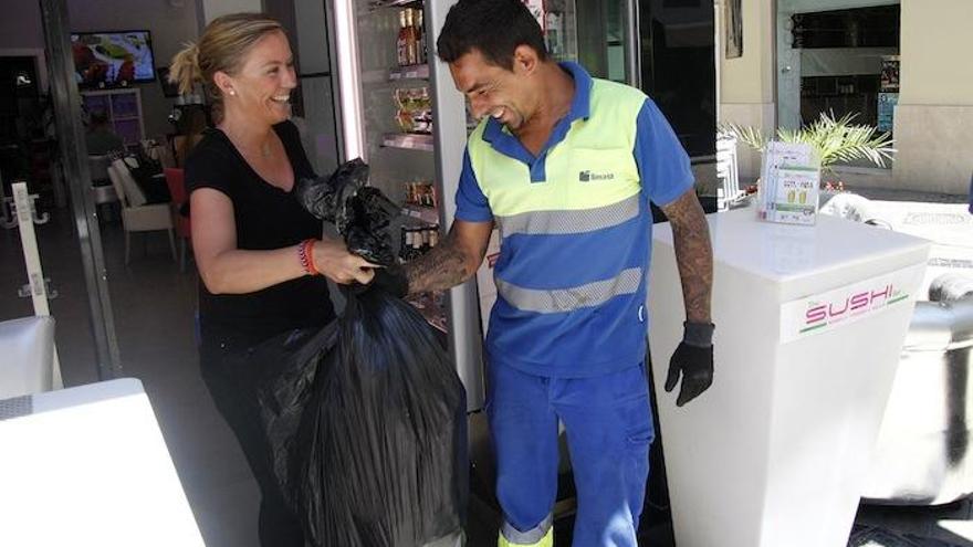 Un operario de Limasa recoge residuos en un establecimiento del Centro.