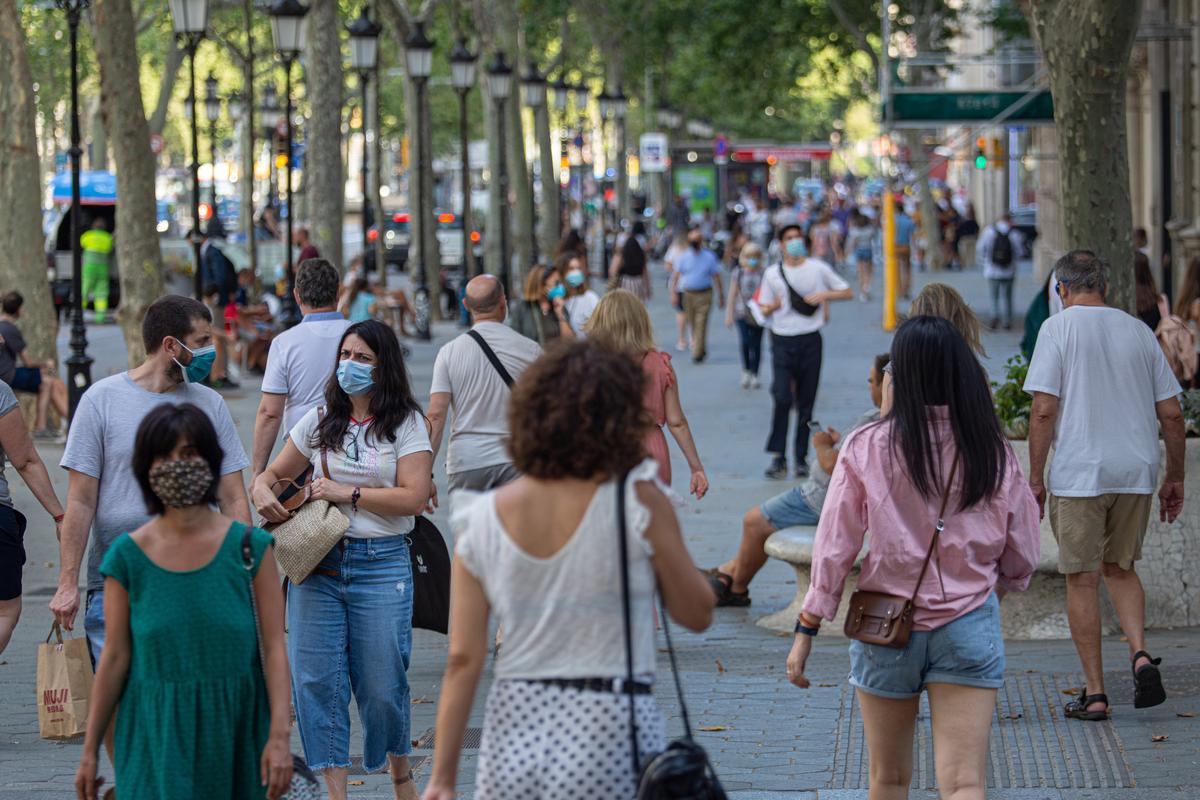 Un grupo de gente paseando con mascarillas por las calles de Barcelona