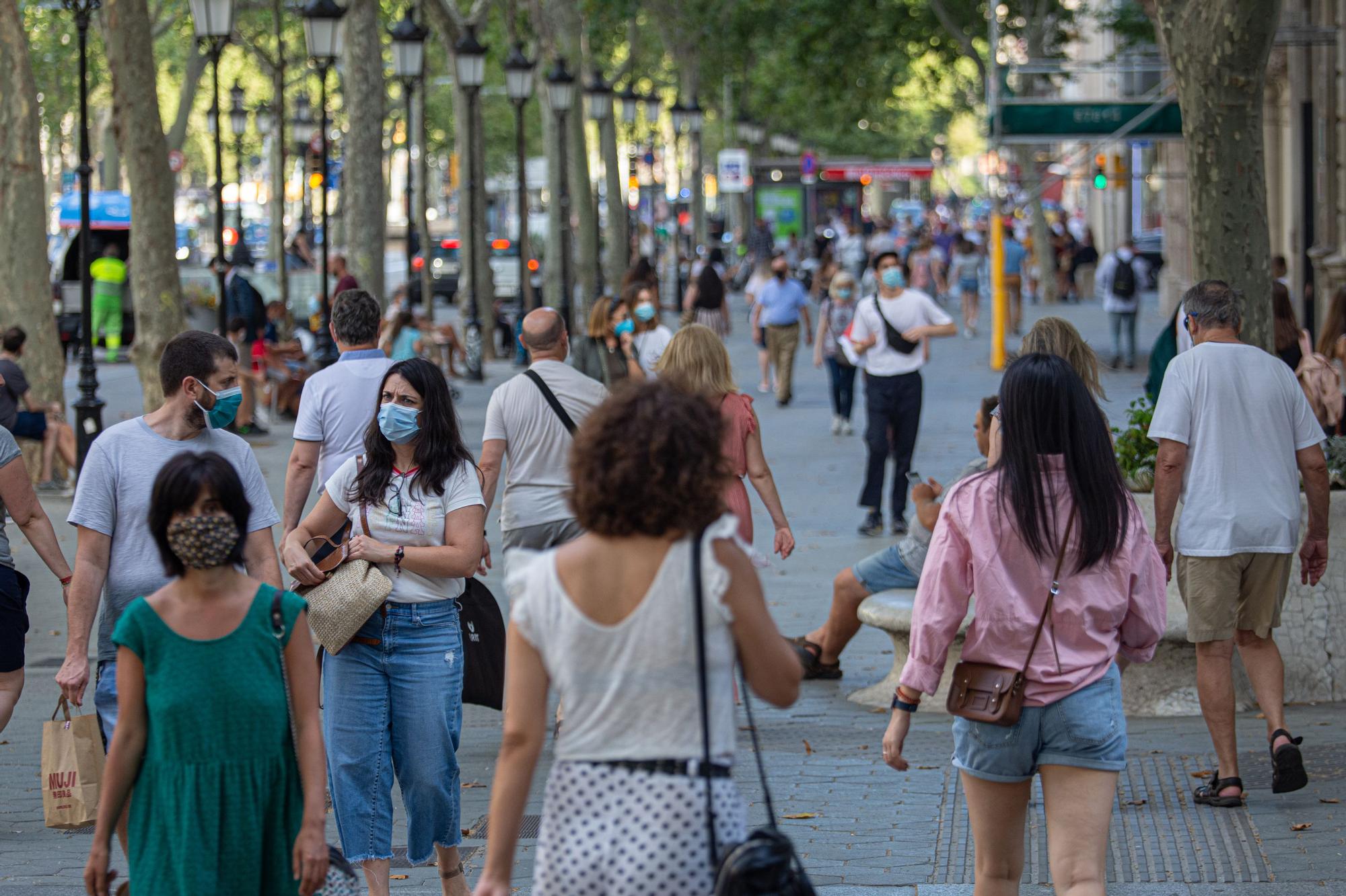 Gente paseando con mascarilla por Barcelona