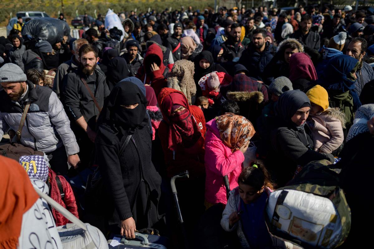 Los residentes sirios de la ciudad de Hatay esperan para cruzar la frontera entre Turquía y Siria después de que se vieron afectados por el terremoto de magnitud 7,8 que asoló la región hace casi dos semanas, en la puerta fronteriza de Cilvegozu