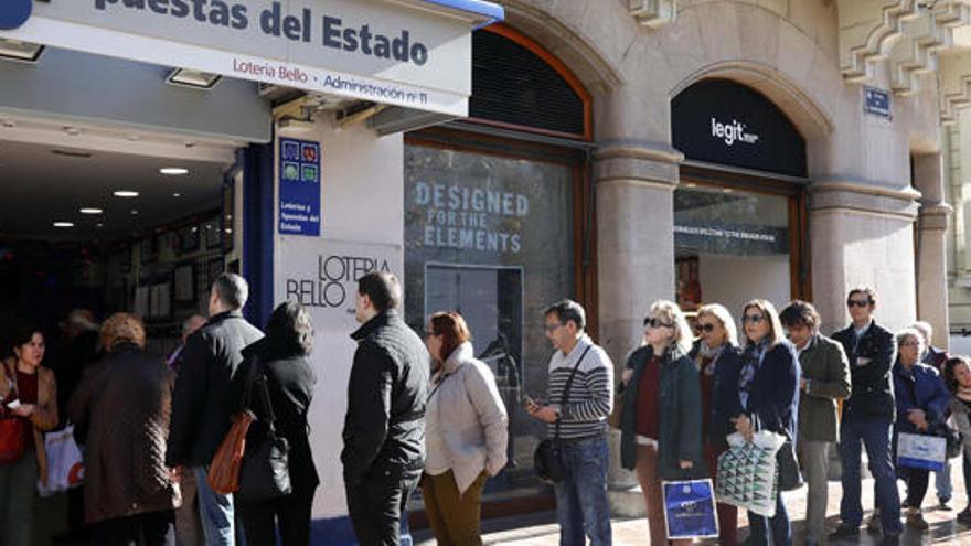 Una fila de personas espera para comprar la Lotería del Niño.