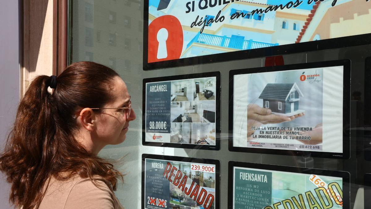 Una joven consulta precios en una inmobiliaria de Córdoba.