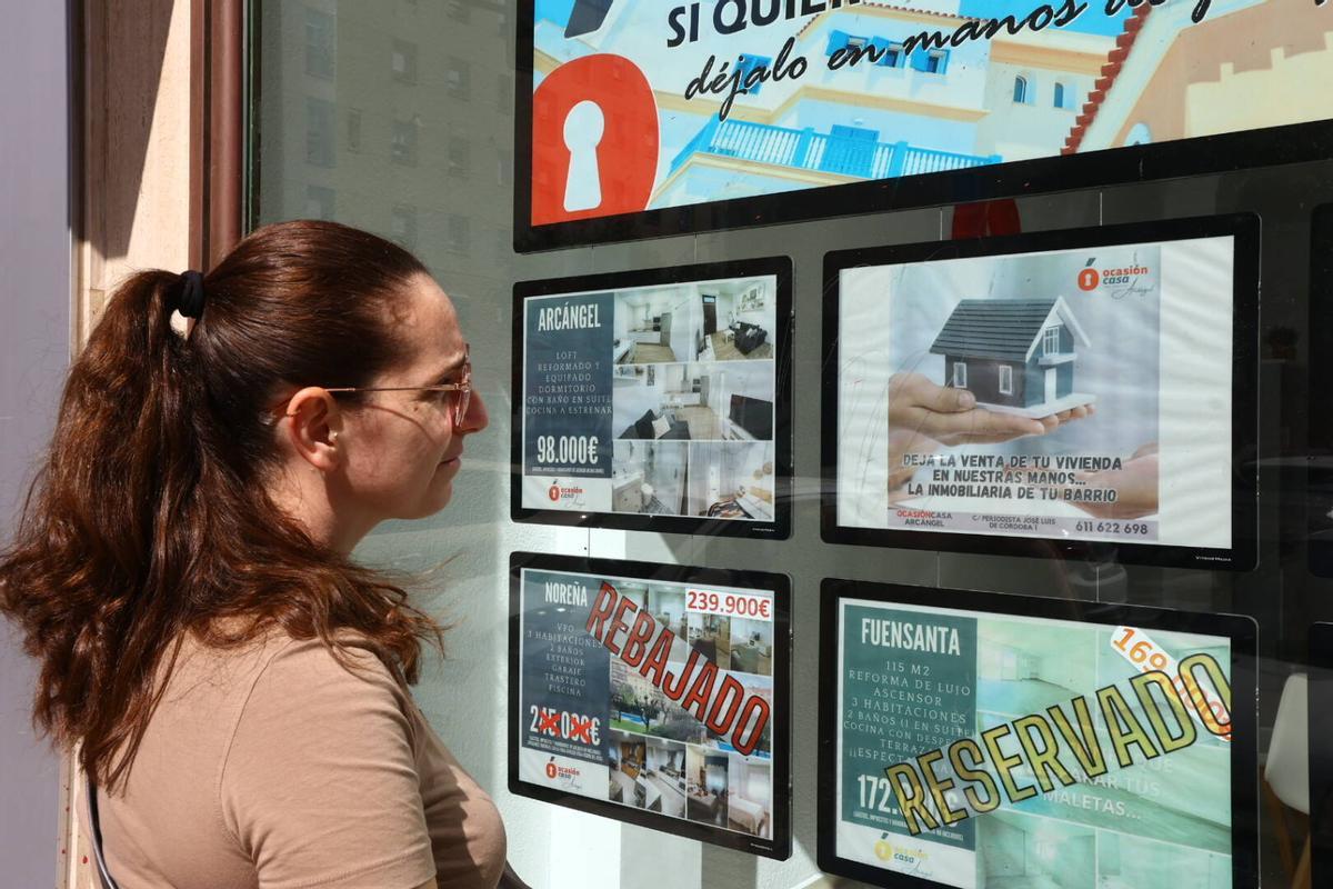 Una joven consulta precios en una inmobiliaria de Córdoba.