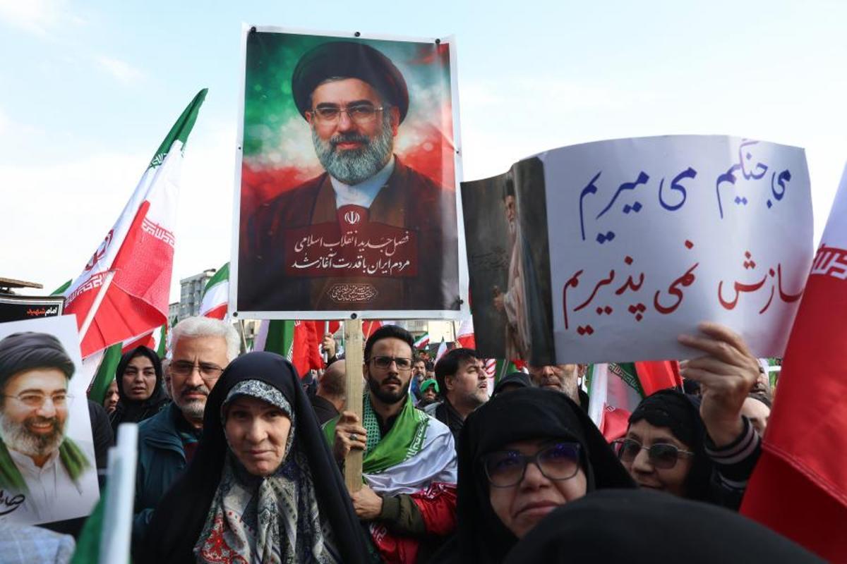 Un hombre enarbola una foto del ayatolá Mojtaba Jamenei en una manifestación de lealtad al nuevo líder iraní el día 9 en Teherán. En la pancarta se lee: "Elegimos morir".