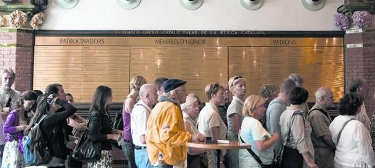 Visitants del Palau de la Música passen pel costat del mural on es consignen els patrocinadors, membres honorífics i patrons de la fundació. Visitants del Palau de la Música passen pel costat del mural on es consignen els patrocinadors, membres honorífics i patrons de la fundació.