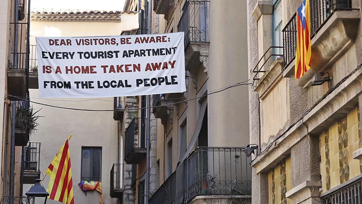 Pancarta al Barri Vell advertint que els pisos turístics treuen habitatge del mercat. | ANIOL RESCLOSA