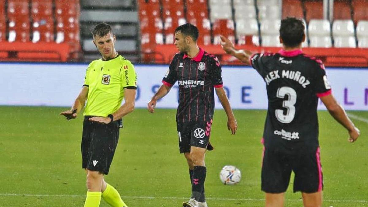 Moreno Aragón pide calma a Álex Muñoz en el Almería-Tenerife, en el que pitó también un discutible penalti de Bruno Wilson en contra del Tenerife.