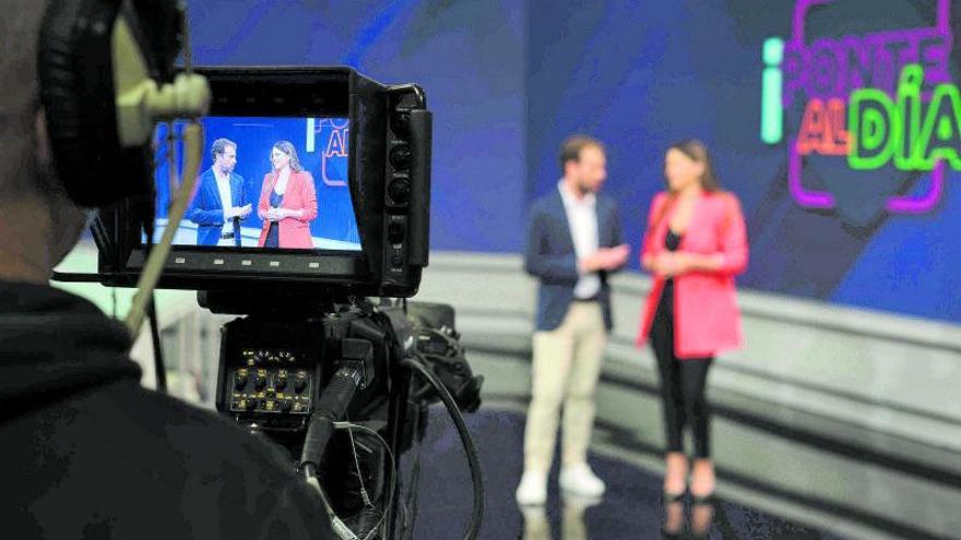 Los dos conductores del programa en  plató, enfocados por un cámara.